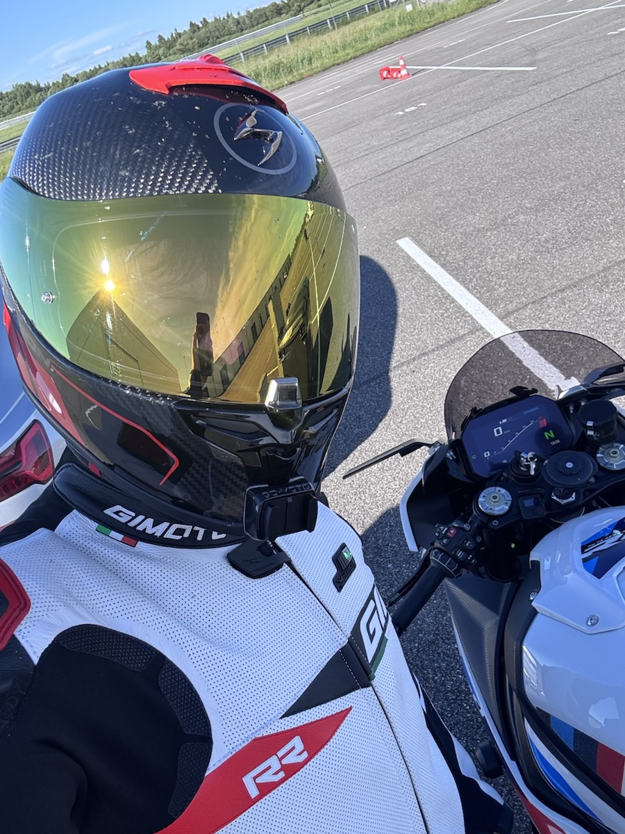 Helmet with gold iridium visor next to the bike's dash