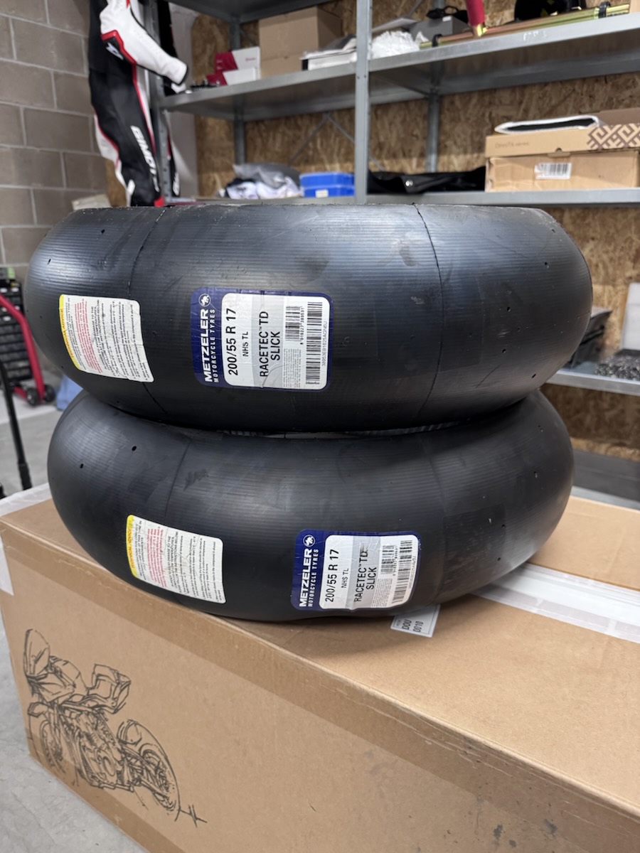 Two new Metzeler Racetec TD slicks, 200/55 R17, stacked in the workshop