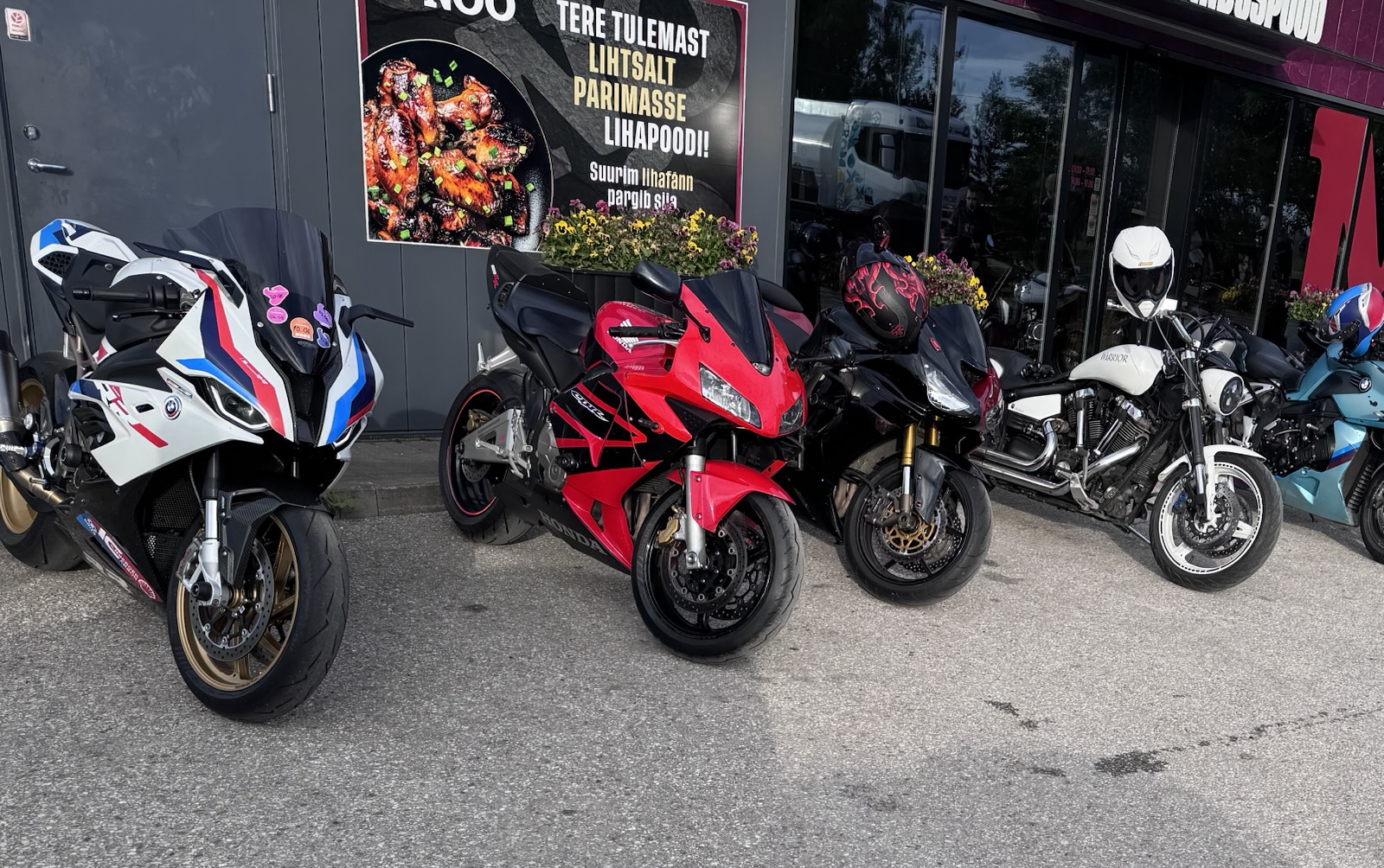 The S 1000 RR parked with a row of other bikes outside a shop front
