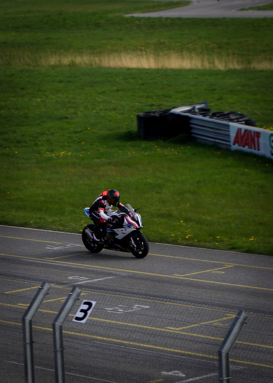 Rider on track with grid marking number 3 in the foreground