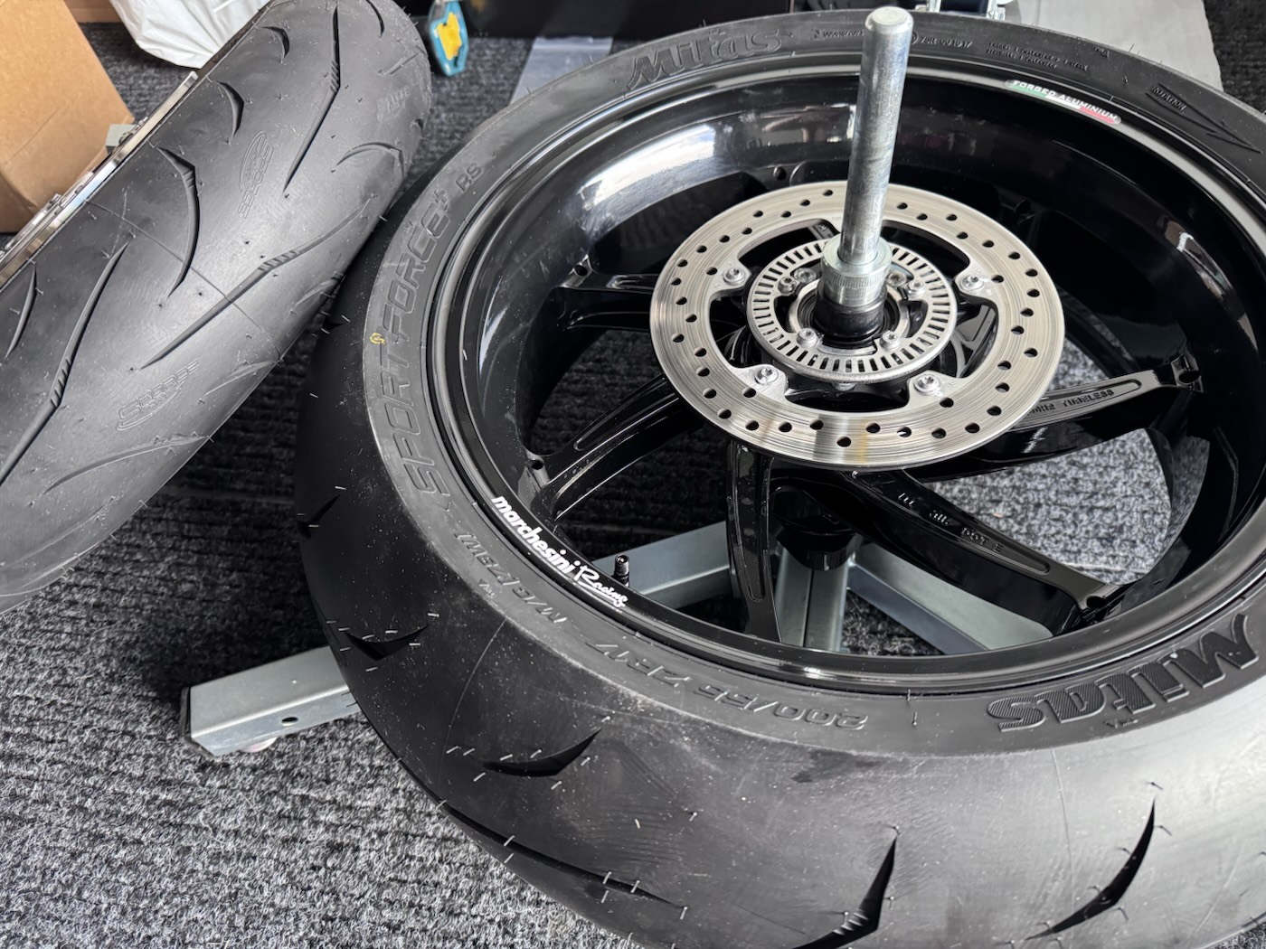 Forged black wheel on a stand with a new road tyre fitted